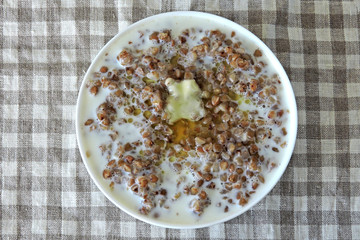 Buckwheat porridge with milk and butter. Healthy breakfast or snack. Dietary food.