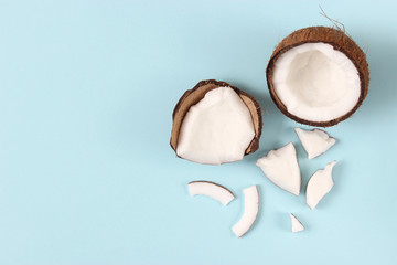 broken coconut on a colored background top view.
