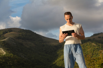 A man in the mountains with tablet computer, global technologies