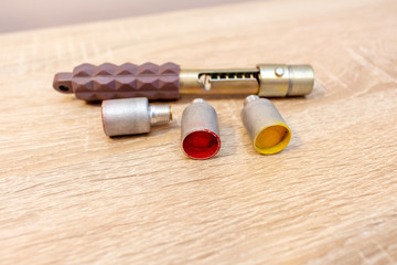 small hand-held rocket launcher with multi-colored rockets shells on a wooden background hunters...
