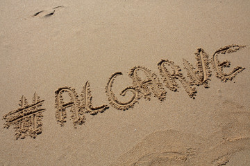 hashtag written by hand in the sand