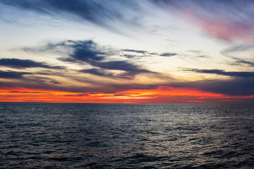 Obraz premium Amazing sunset, sea, the sun with clouds and sun reflection. Open ocean view from boat