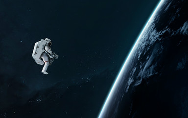 Astronaut orbiting Earth planet, EVA, science fiction image. Elements of this image furnished by...