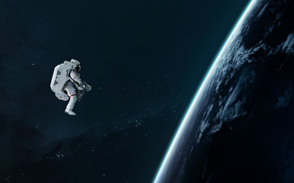 Astronaut orbiting Earth planet, EVA, science fiction image. Elements of this image furnished by NASA