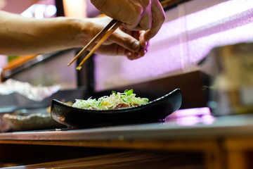 preparation of japanese food including sushi and salad