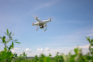 Close up on white drone camera. Drone quadcopter in flight