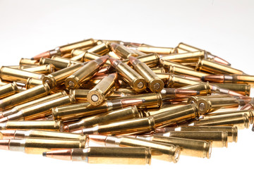 cartridges for 308 caliber rifle on a white background. a bunch of ammo. cartridges scattered on a light background