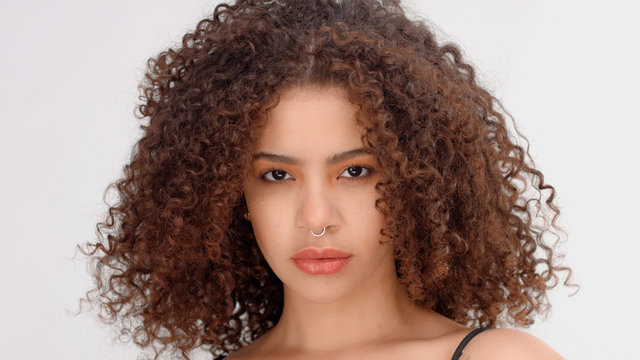 hair blowing closeup portrait of mixed race model with freckles calm watching to the camera