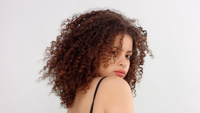 hair blowing closeup portrait of mixed race model with freckles backside shood and model turned her face to the camera