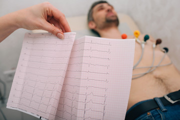 patient getting heart rate monitored with electrocardiogram equipment. cardiogram test, Close-up Of Ecg Report - obrazy, fototapety, plakaty