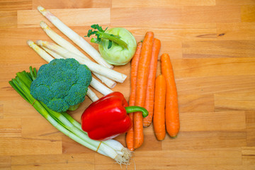 Carrots, Broccoli, Spring Onions, Kohlrabi and Asparagus on Wooden Background