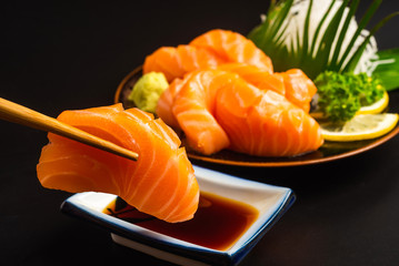 Sashimi, Salmon, Japanese food chopsticks and wasabi on the wood table - obrazy, fototapety, plakaty