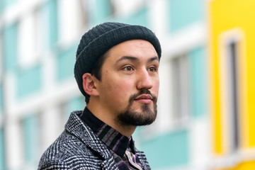 Portrait of a stylish handsome young man with a coat outdoors.  A man wearing a coat and a shirt looking away and wondering