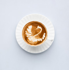 Cup of coffee with the image of a swan on a white background, top view