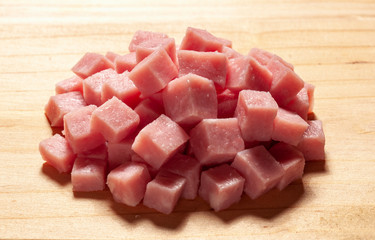 Close-up of diced ham on light wooden surface