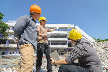 Engineer team and worker checking blueprint for emolition construction plan and inspect at the site.
