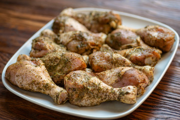 Chicken drumsticks  on white dish, wooden background