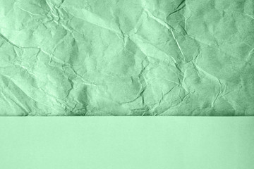 Crumpled and plain paper sheets divided creating line partition. Trendy neo mint colored abstract background design. Flat lay. Color of the year 2020