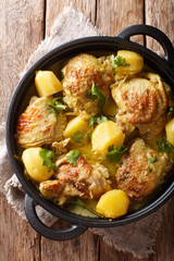 Popular spicy chicken coconut curry with potatoes close-up in a pan. Vertical top view