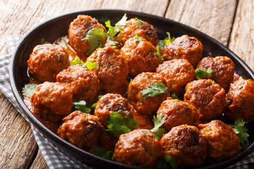 Homemade chicken meatballs in coconut curry sauce with cilantro close-up on a plate. horizontal