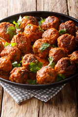 Delicious chicken meatballs in a creamy coconut sauce with curry closeup on a plate. vertical
