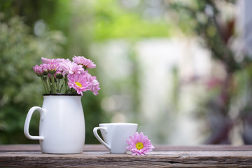 white coffee cup with flower pot on wooden table