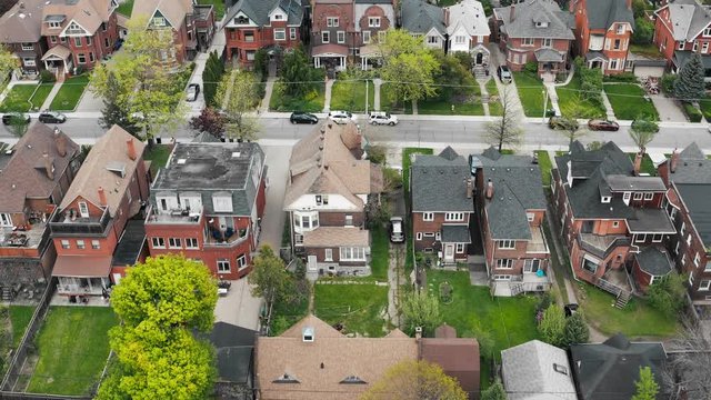 Aerial view of residential homes in late spring. Cinematic 4K establishing shot.