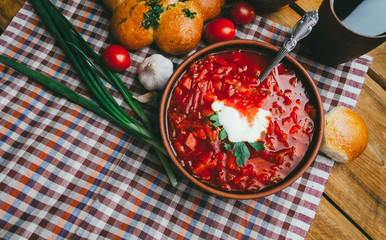 Fototapeta na wymiar National soup of Ukrainian cuisine - borsch with sour cream and donuts. Nourishing, nutritious and tasty lunch of a peasant.