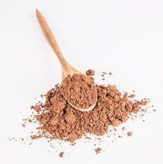 cocoa powder and wooden spoon on white