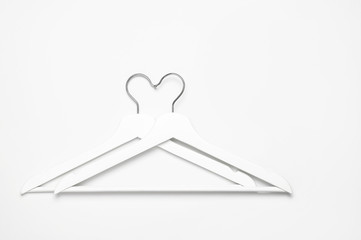 Flat lay top view White wooden hangers on white background copy space minimalism style. Sale discount store shopping concept, design empty hanger. Creative fashion beauty feminine blog