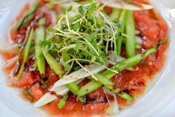 asparagus with tomato sauce on a white plate