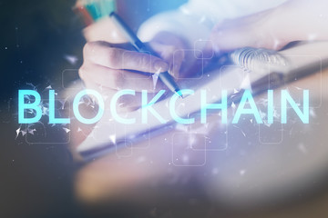 Cryptocurrency hologram, bitcoin, ico theme over hands taking notes background. Concept of blockchain. Multi exposure