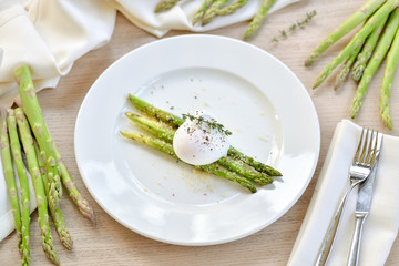 poached egg with asparagus on a white plate