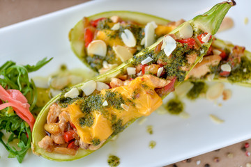 baked zucchini with cheese and vegetables on a rectangular plate