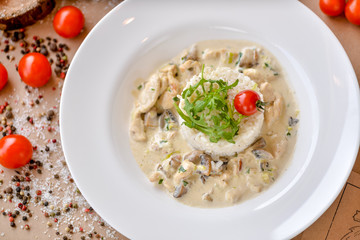 rice in a plate with sauce decorated with arugula and tomato