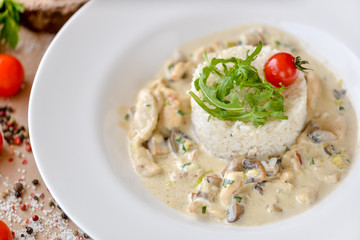rice in a plate with sauce decorated with arugula and tomato
