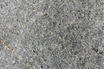 Closeup macro view of gray rough stone surface. Detailed nature pattern texture or background taken in natural environment. Weathered over years, unique and inimitable effect to textured design.