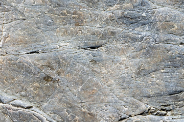 Close up macro view of cracked stone surface gray color. Detailed nature background or pattern texture taken in natural environment. Weathered many years, inimitable, unique effect to textured design