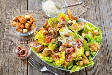 Leckerer Römersalat mit gegrillten Hähnchenbruststreifen, Sardellen, Speck, Croutons und Parmesan -  Delicious Caesar Salad with grilled chicken, bacon, croutons, anchovy fillets and parmesan cheese