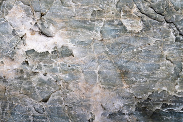 Closeup macro view of gray color stone surface. Detailed nature texture or pattern background taken in natural environment. Weathered many years, unique and inimitable effect to textured design.
