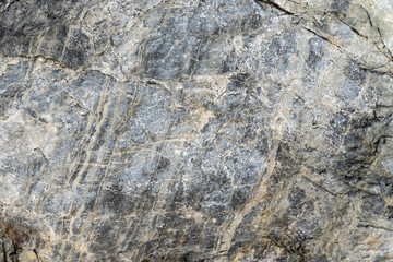 Close-up macro view of rough stone surface gray color. Detailed nature background or pattern texture taken in natural environment. Weathered many years, inimitable and unique effect to textured design