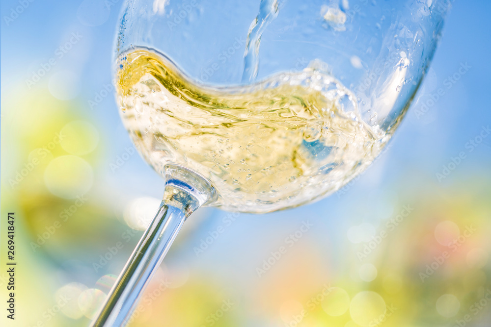 Wall mural colorful close-up of pouring white wine in a glass