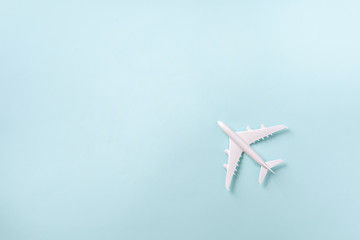 White plane, airplane on blue pastel color background with copy space. Top view, flat lay. Minimal...
