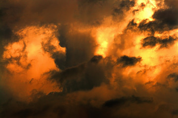 Fototapeta premium Dark clouds illuminated by the bright light of the sun. Apocalyptic dramatic background.