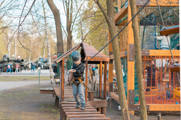 Fototapeta na wymiar A little boy is passing an obstacle course. Active physical recreation of the child in the fresh air in the park. Training for children.