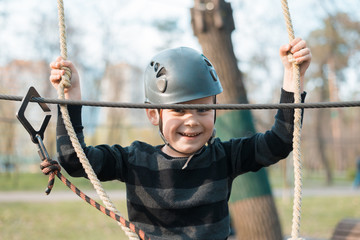 A little boy is passing an obstacle course. Active physical recreation of the child in the fresh air in the park. Training for children.