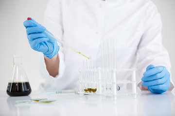 Fototapeta premium Scientist working with pharmaceutical cbd oil in a laboratory with glass dropper and a bowl