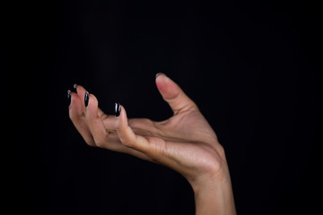 Woman's hand palm up on black background.