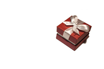 A beautiful red box with a white ribbon. Packaging for a gift on a holiday.