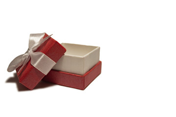 A beautiful red box with a white ribbon. Packaging for a gift on a holiday.
